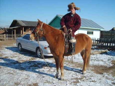 Mongolian man riding a horse Mongolian man riding a horse