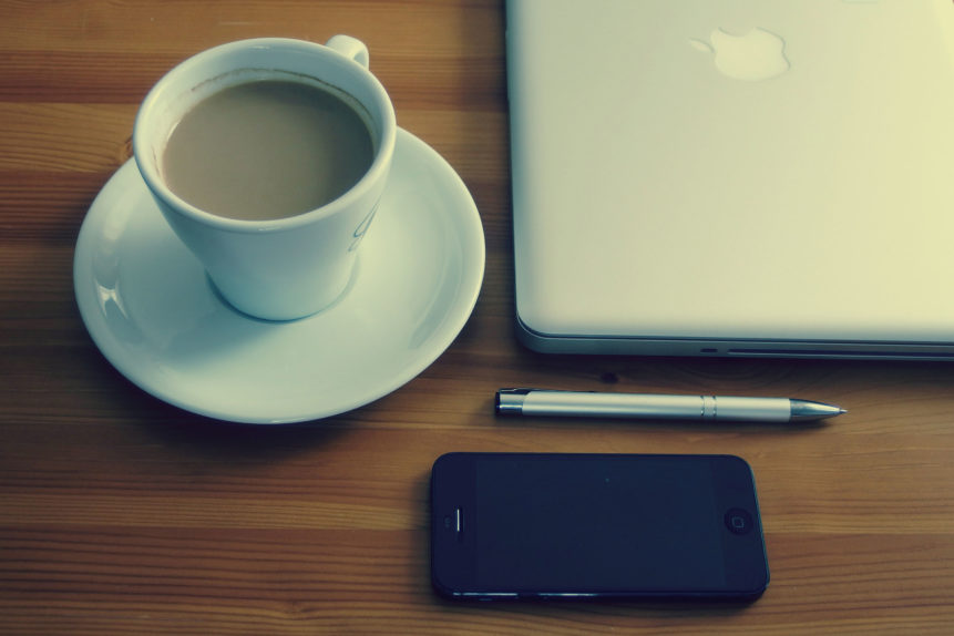 Free photo: Coffee and Laptop. Black iPhone 4, pen, cafe in white cup and Apple Macbook on the wooden table.