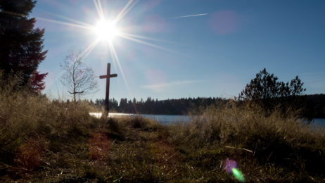 Sun over the lake and a crucifix Sun over the lake and a crucifix