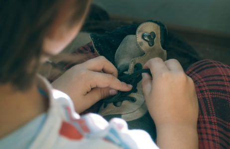 Boy trying to tie his shoes Boy trying to tie his shoes