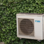 Air conditioner compressor on the ivy wall Air conditioner
