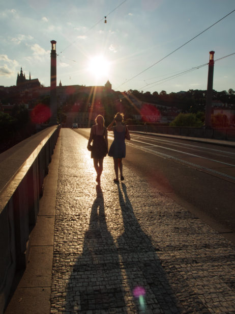 Two tourists – girls walking on the Prague bridge Two tourists – girls walking on the Prague bridge