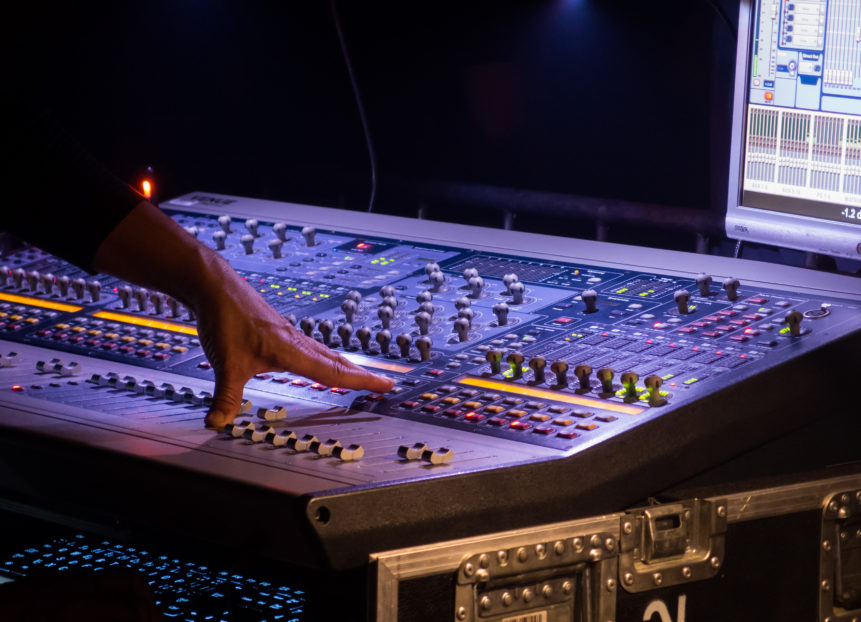 Soundman Behind a Mixer At Concert