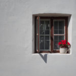 Vintage window with red roses white wall