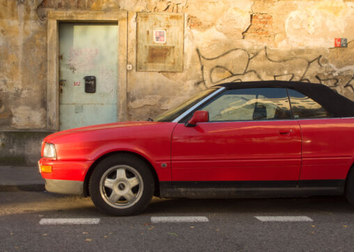 Rotes Auto-Cabrio mit Schmutzwand