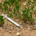 Hypodermic Syringe On The Ground