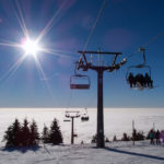 A chair lift at the top of a mountain on a sunny day winter sunny day on ski slope