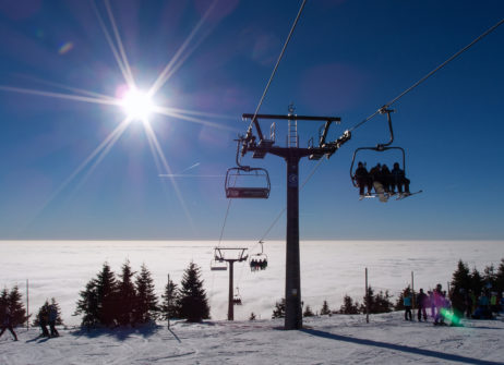 A chair lift at the top of a mountain on a sunny day A chair lift at the top of a mountain on a sunny day
