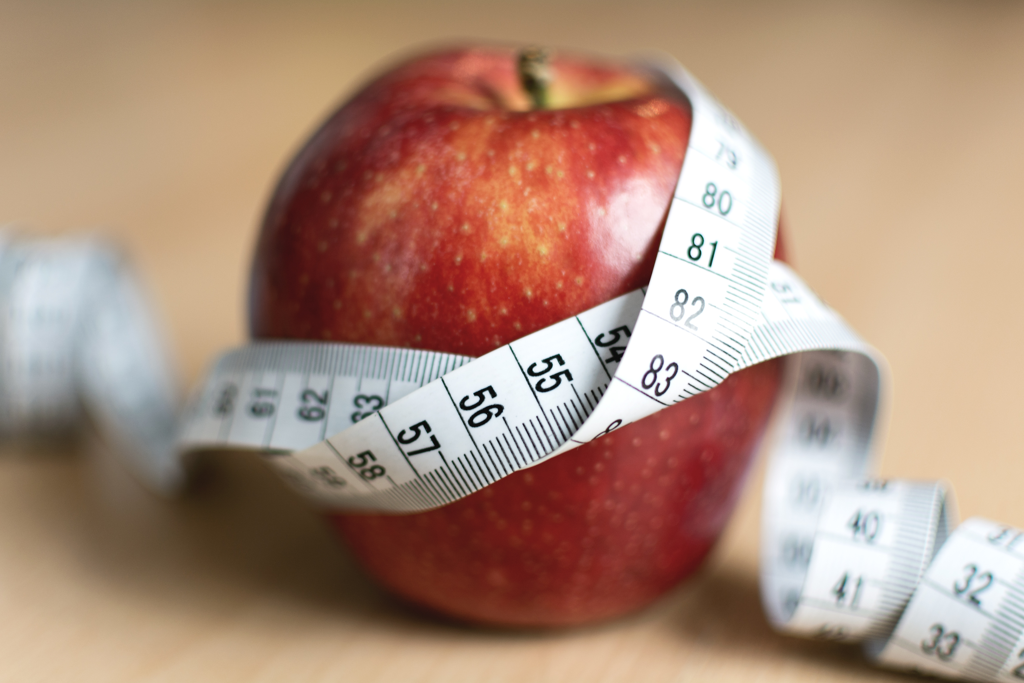 Red apple and yellow measuring tape to symbolize an healthy diet and body weight  control Stock Photo - Alamy