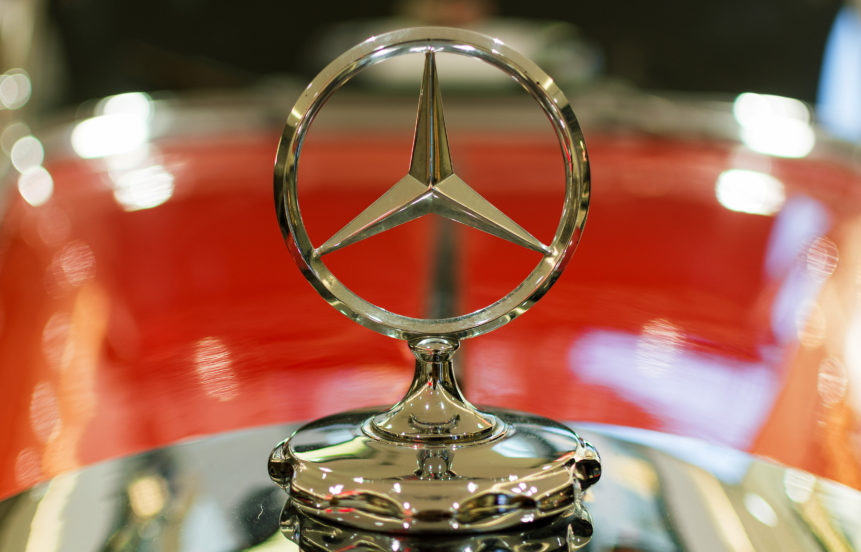The Mercedes-Benz logo on a classic red oldtimer