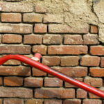 Old brick wall with red handrail
