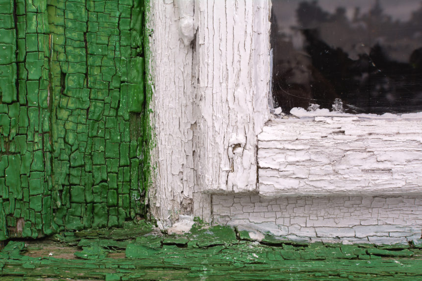 Old wooden window close up with visible structure of green and white color wood.