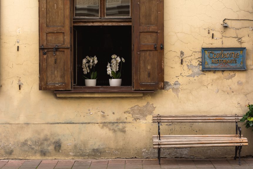 Italian street detail with window, bench and restaurant sign