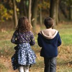 Boy and girl siblings walking in the woods