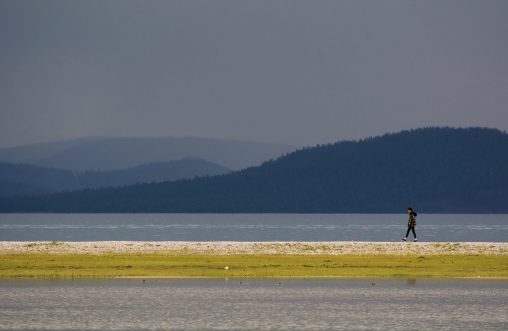 Lonely girl walking by the lake