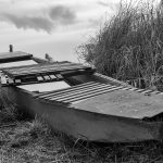 Old wooden punt on the bank of the pond