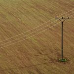 electricity poles on the brown field