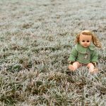 Creepy Doll Sitting in a Meadow Creepy doll sitting in a meadow