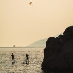 Silhouette of two people on paddleboards