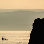 Photo of a man on a paddleboard at sunset in Croatia. Photo is for free use.