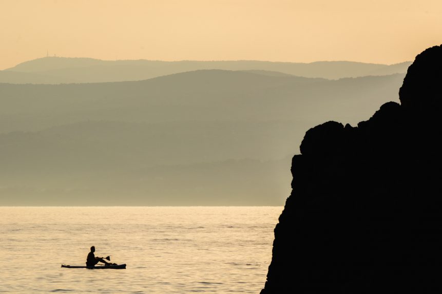 Photo of a man on a paddleboard at sunset in Croatia. Photo is for free use.